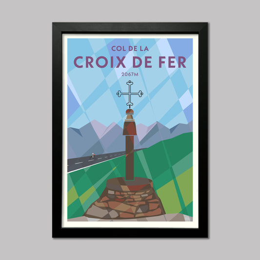 Print of a cyclist riding past the Iron Cross at the top of the Col de la Croix de Fer in the French Alps. Presented in a black frame.