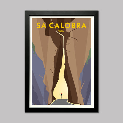 Print of a cyclist riding through the rock arch on the climb from Sa Calobra port in Mallorca. Presented in a black frame.