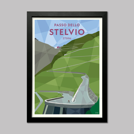 Print of a cyclist on the climb up to the Stelvio pass. The white stone walled hairpins are visible winding up the road ahead. Presented in a black frame